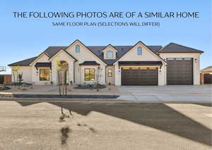 French country home with stucco siding, an attached garage, driveway, a standing seam roof, and stone siding