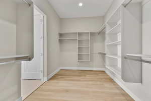 Walk in closet with light wood-style flooring