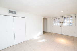 Entrance foyer with a textured ceiling and french doors