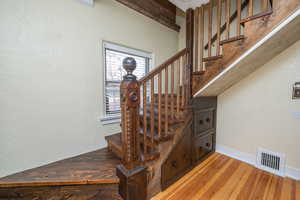 Stairs featuring a textured wall and hardwood / wood-style floors