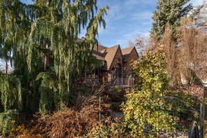 View of home's exterior featuring stone siding and a shingled roof