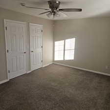 Unfurnished bedroom featuring dark colored carpet and a ceiling fan