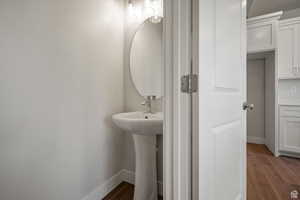 Half bathroom with dark wood-style flooring and baseboards