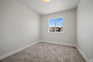 Empty room featuring light colored carpet and a textured ceiling