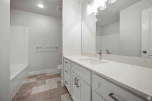 Full bath with vanity, a textured ceiling, and shower / bath combination