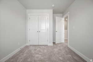 Unfurnished bedroom featuring carpet and a closet