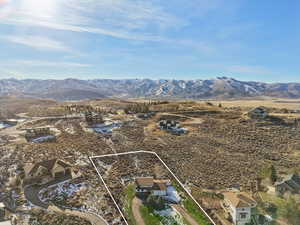 Aerial view of property and surrounding area with property boundaries highlighted and mountains