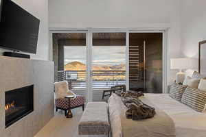 Bedroom featuring a warm lit fireplace