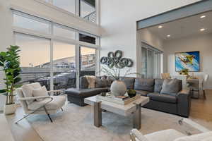 Living room with light wood finished floors, recessed lighting, a towering ceiling, and a mountain view