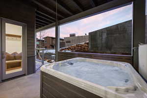 Snow covered patio with a patio area and a hot tub