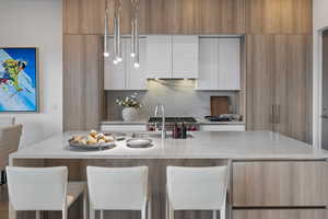 Kitchen with modern cabinets, light stone countertops, and brown cabinetry