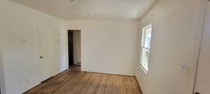Unfurnished room with wood finished floors and baseboards