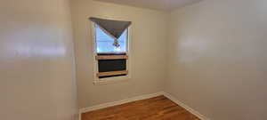 Unfurnished room featuring wood finished floors and baseboards