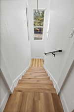 Stairway featuring a textured wall and wood finished floors
