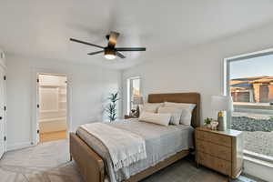 Bedroom featuring a ceiling fan, connected bathroom, and carpet
