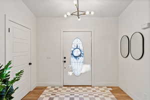 Foyer featuring a chandelier and light wood-style flooring