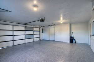 Garage with electric panel and a garage door opener
