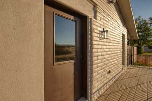 Entrance to property with brick siding and stucco siding