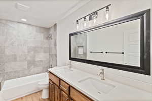 Bathroom featuring double vanity, shower / bathtub combination, and a textured ceiling