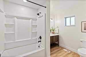 Full bath featuring vanity, shower / tub combination, and light wood-style floors
