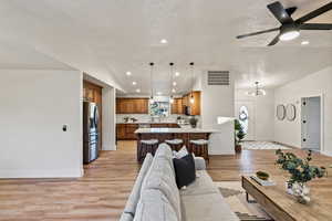 Living area featuring recessed lighting, light wood-style floors, a textured ceiling, and a ceiling fan