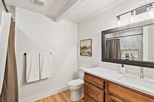 Bathroom featuring vanity, light wood-style flooring, a textured ceiling, and a shower with shower curtain