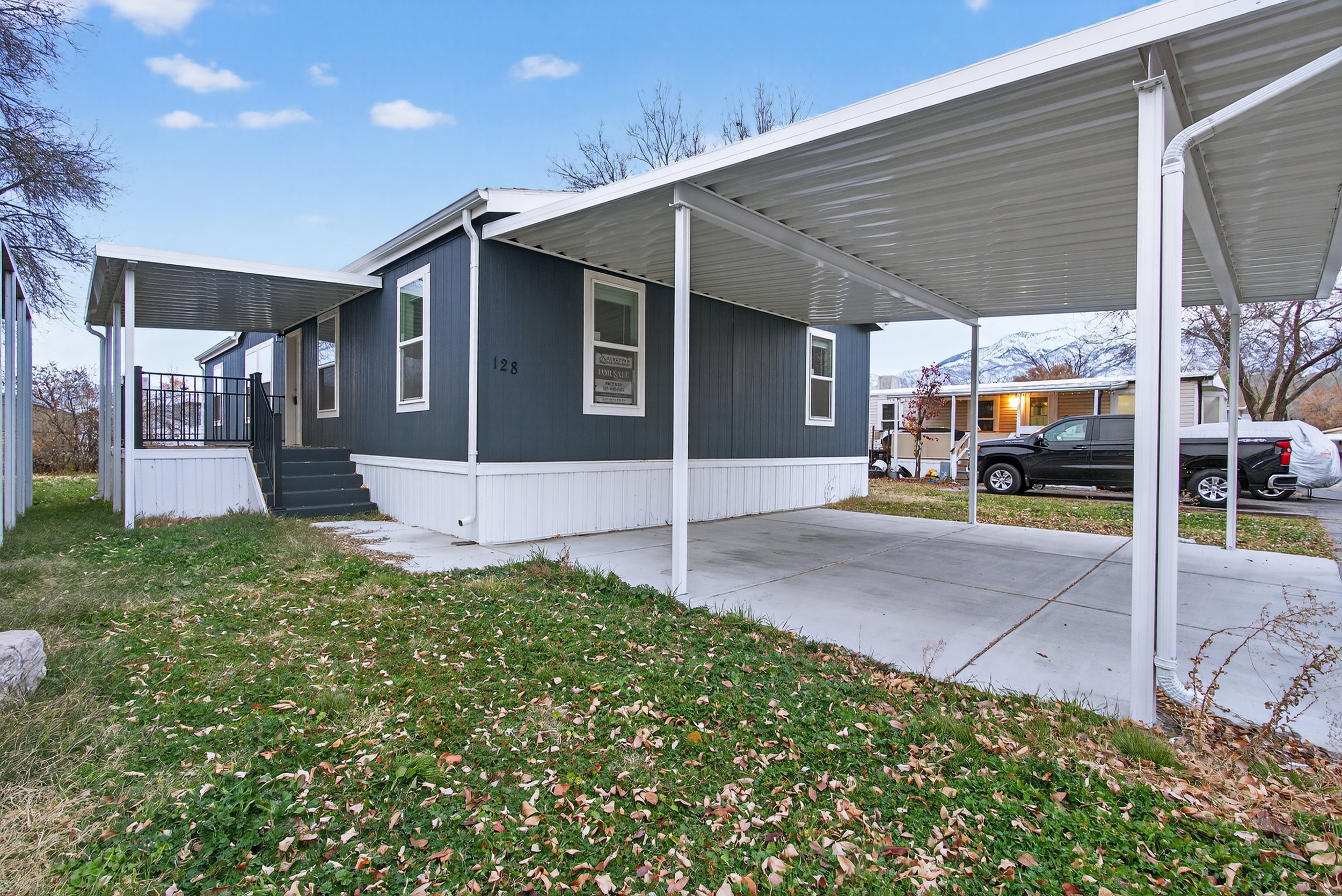 View of home's exterior with an attached carport, a lawn, and a porch