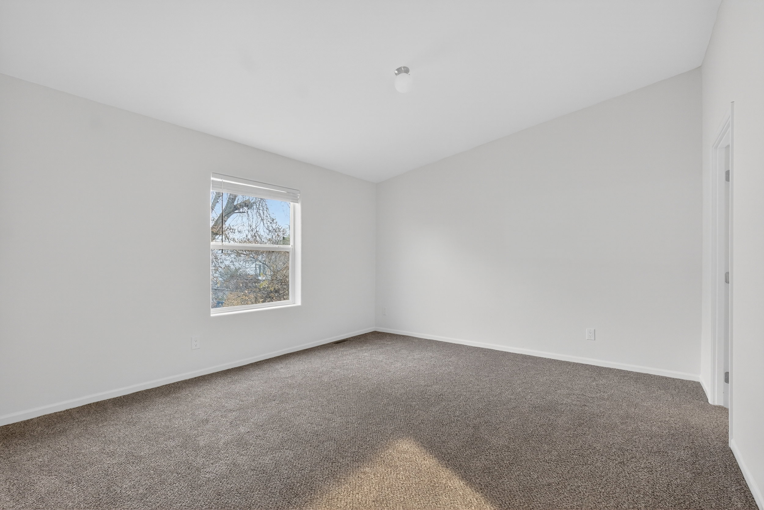 Carpeted spare room featuring baseboards