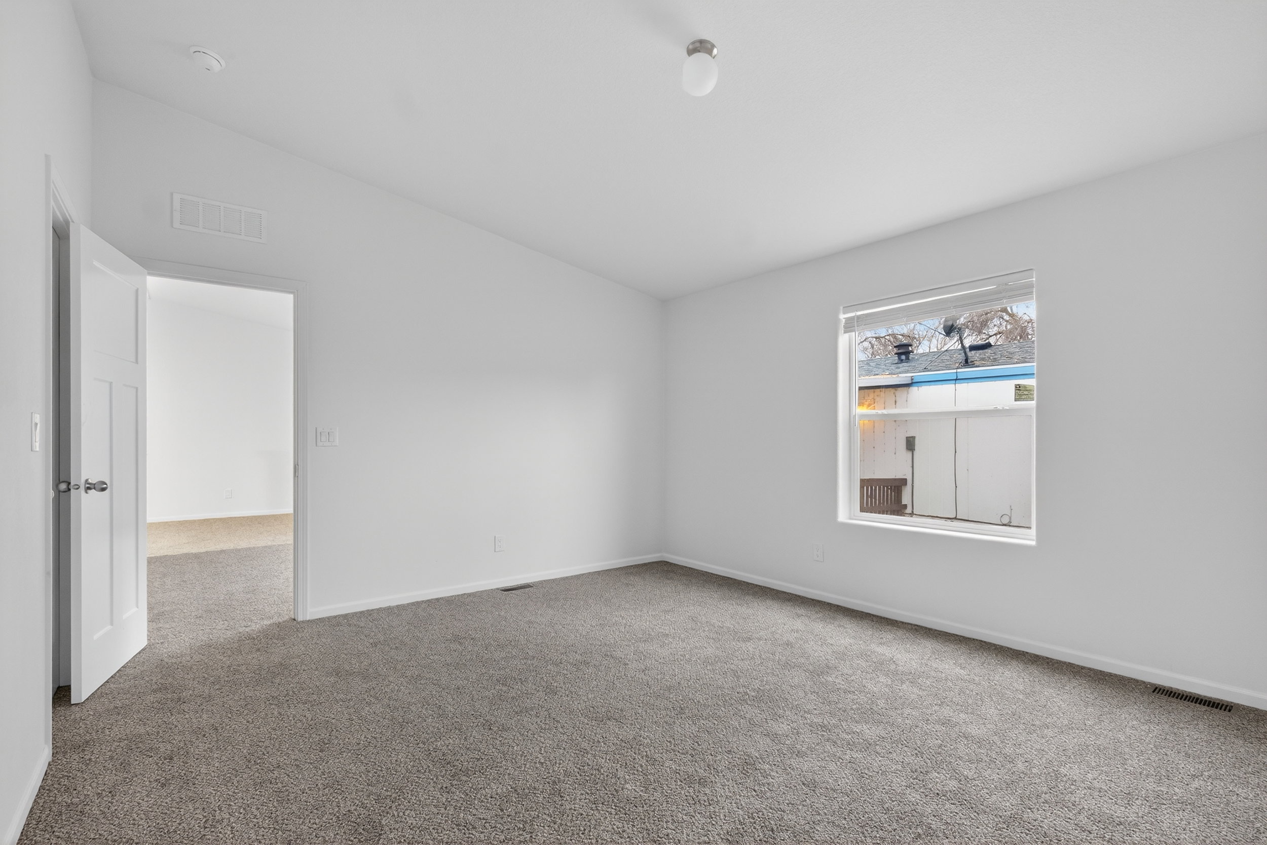 Empty room with lofted ceiling and carpet floors