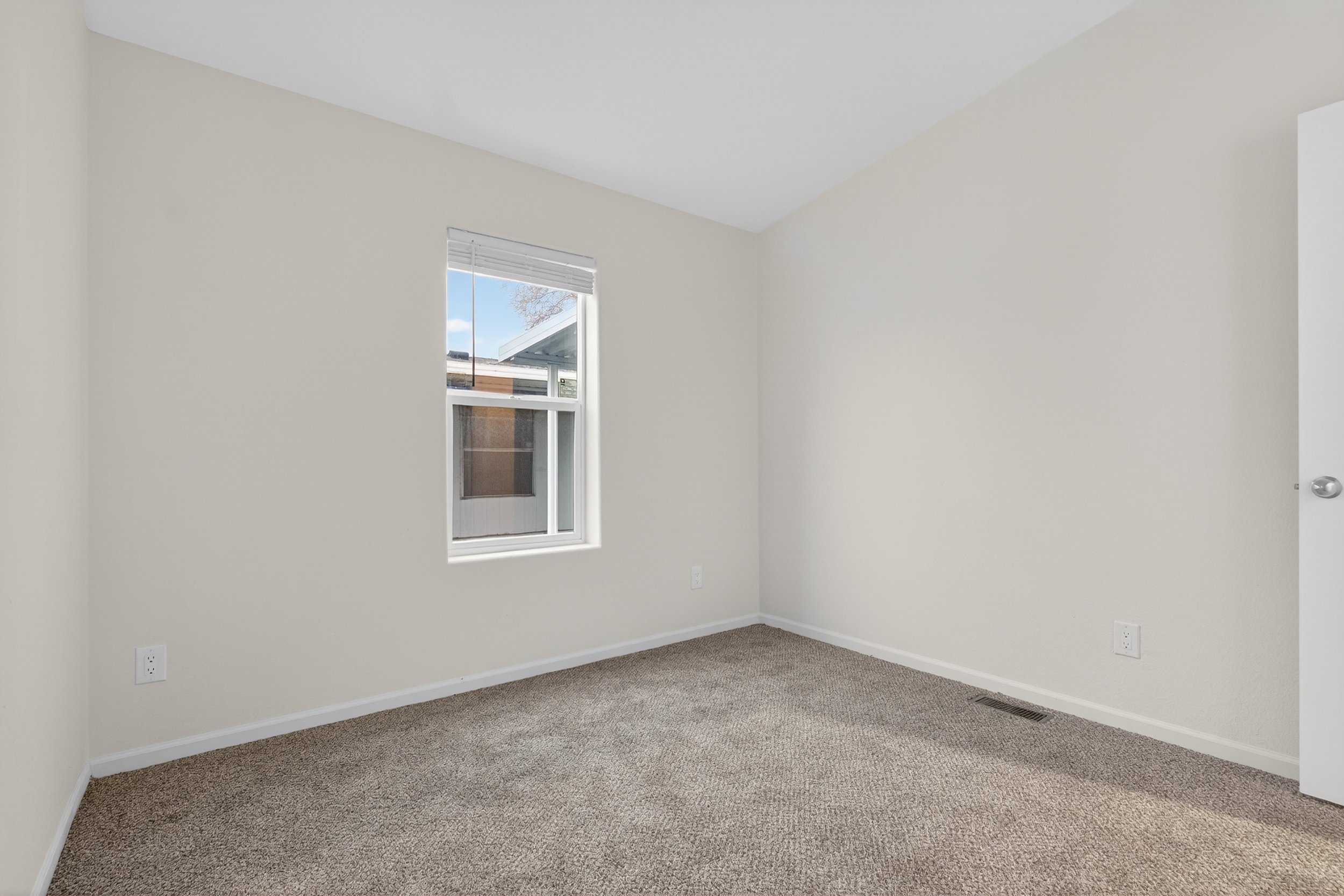 Carpeted empty room with baseboards