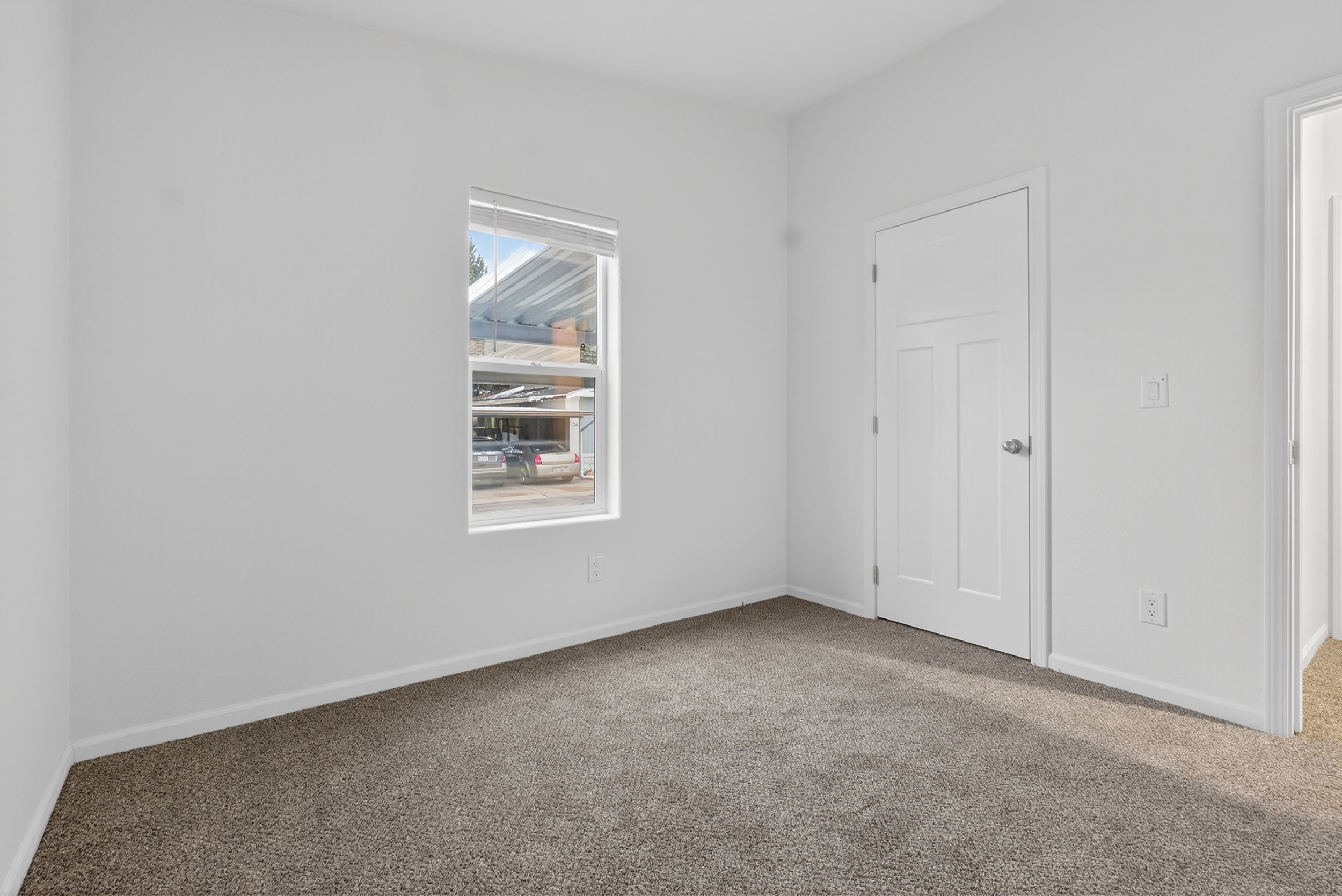 Carpeted spare room featuring baseboards