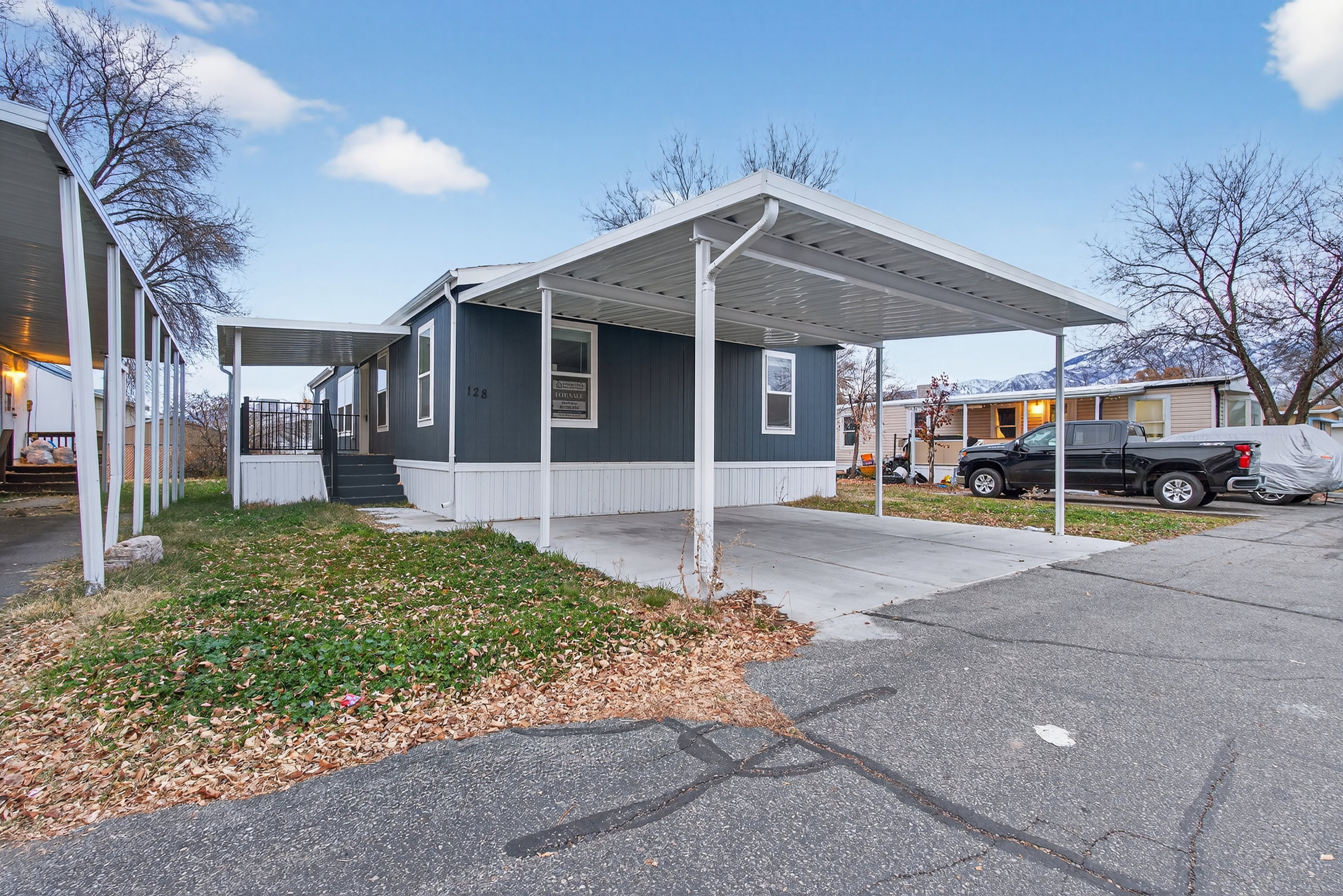 View of side of home with driveway, a carport, and a porch