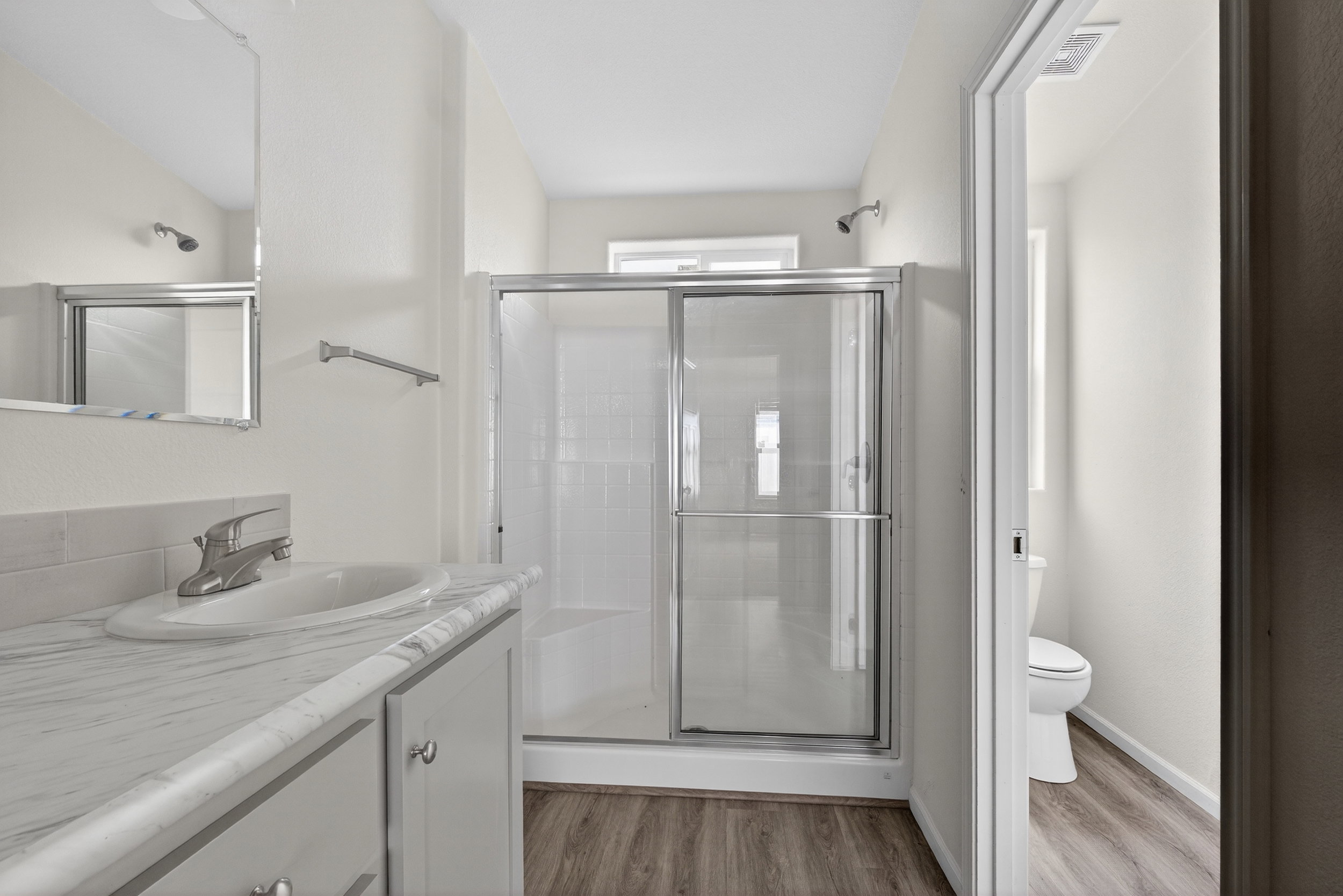 Bathroom featuring vanity, a shower stall, and light wood-type flooring