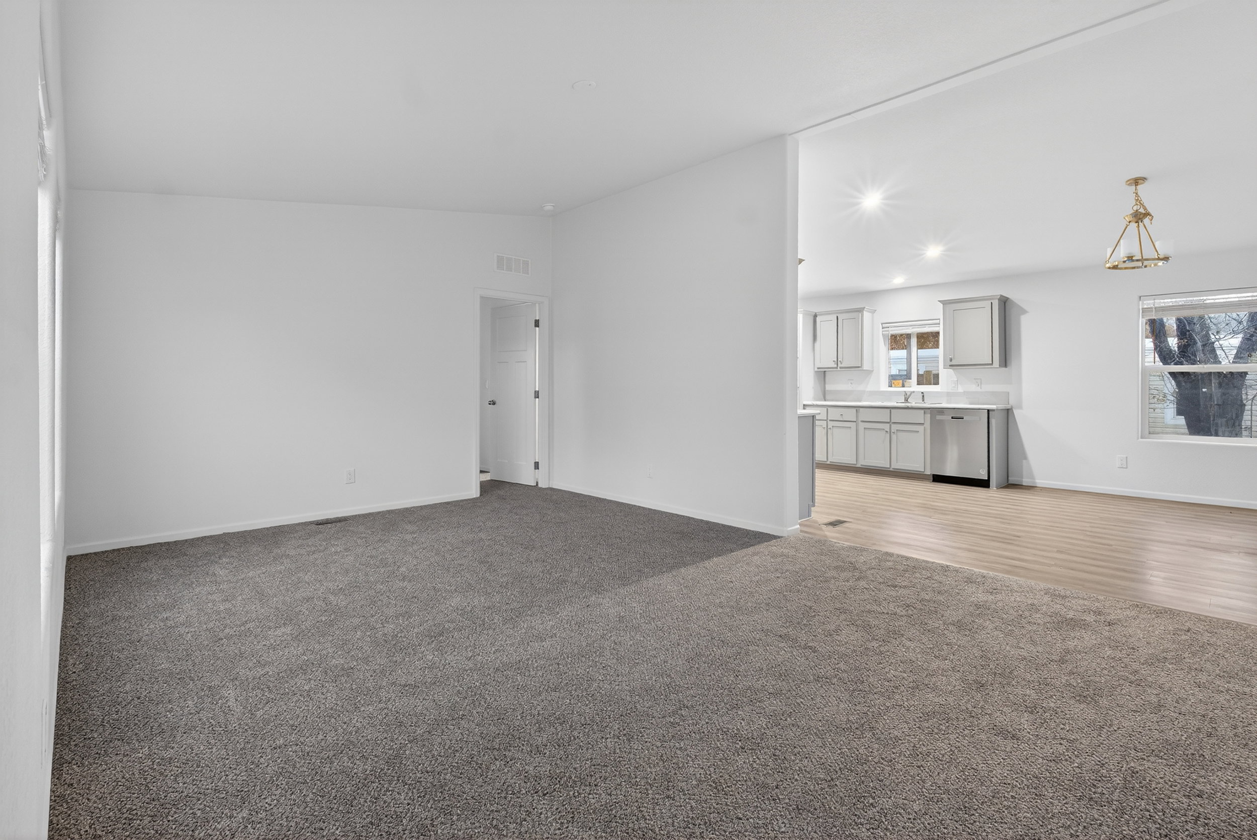 Unfurnished living room featuring dark carpet, lofted ceiling, and recessed lighting
