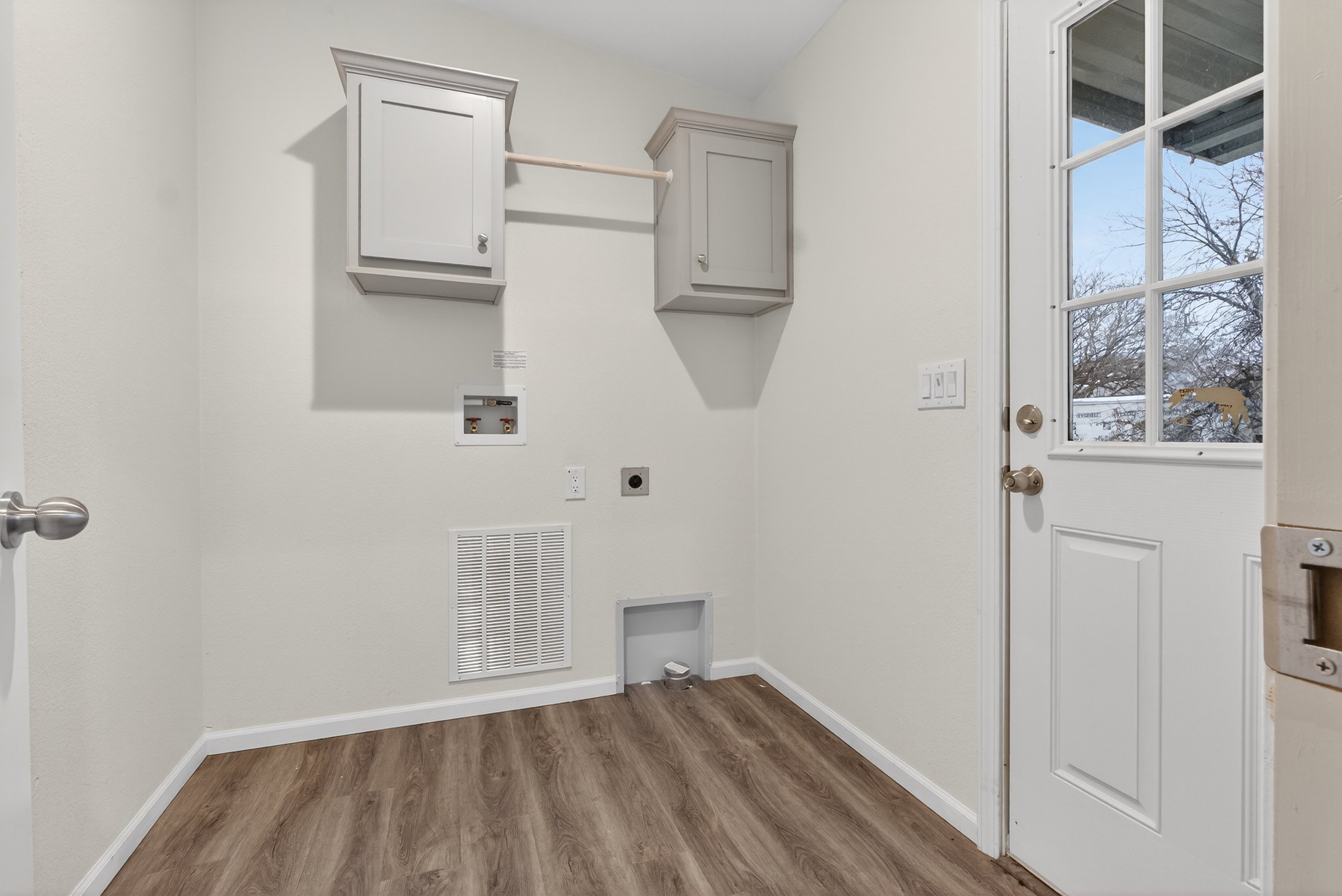 Laundry area featuring cabinet space, hookup for an electric dryer, dark wood-style flooring, and washer hookup