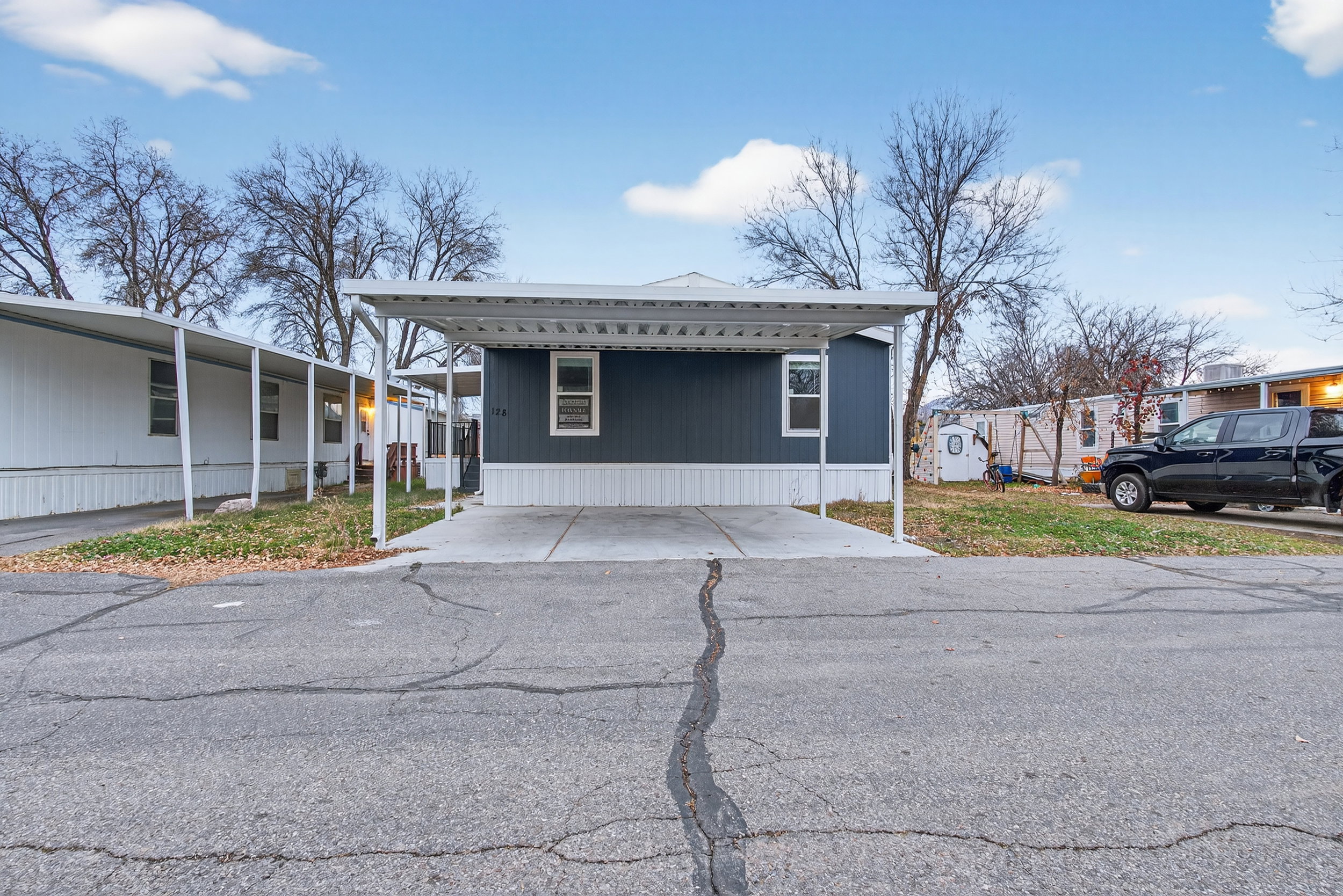 View of front facade with a carport and driveway