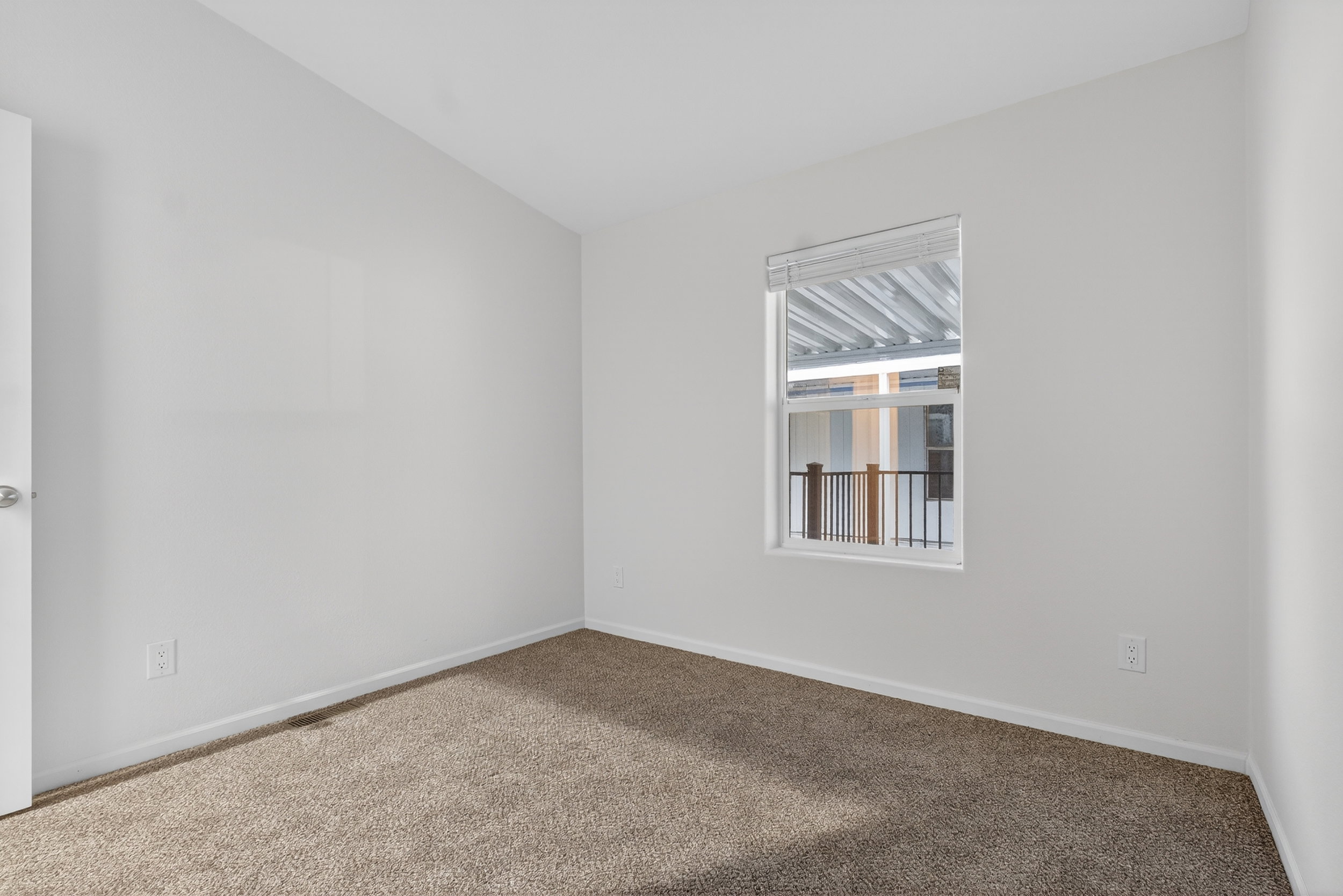 Empty room with carpet and baseboards