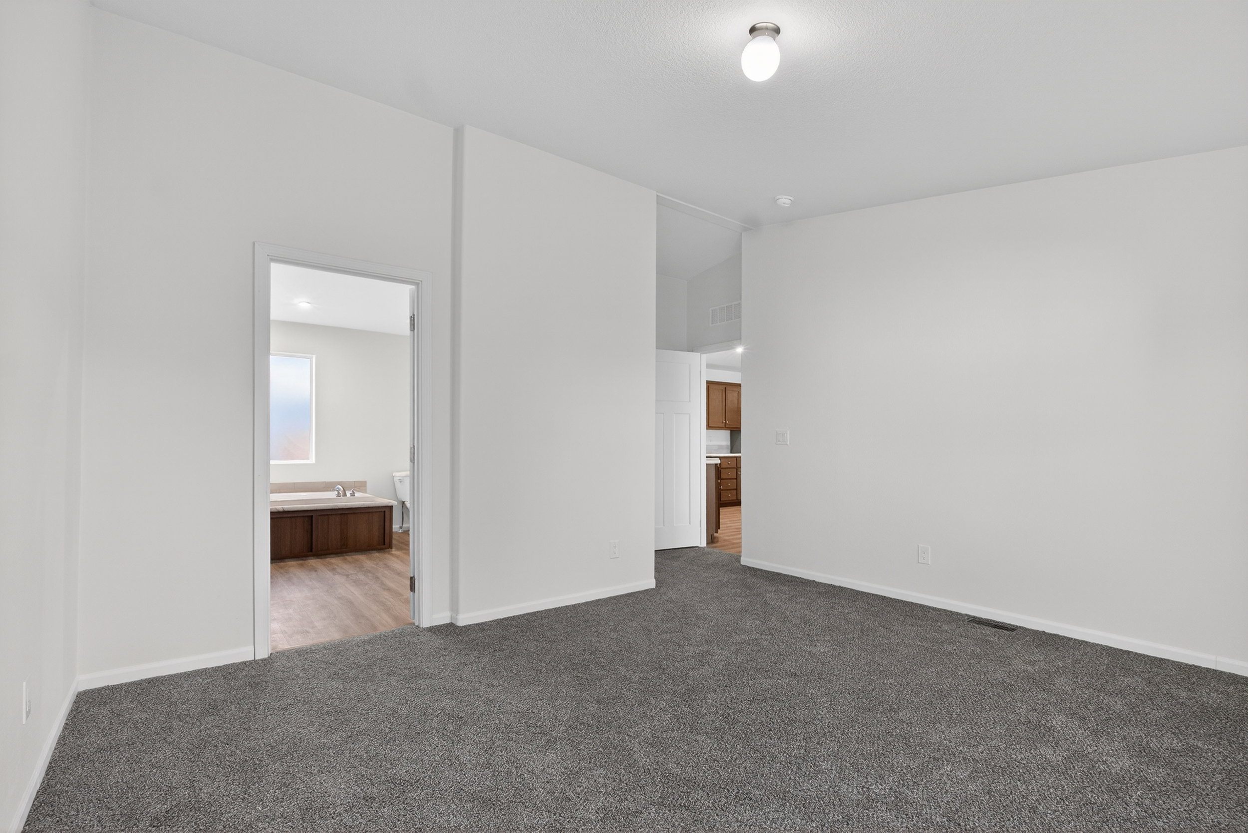 Unfurnished bedroom with connected bathroom and carpet flooring