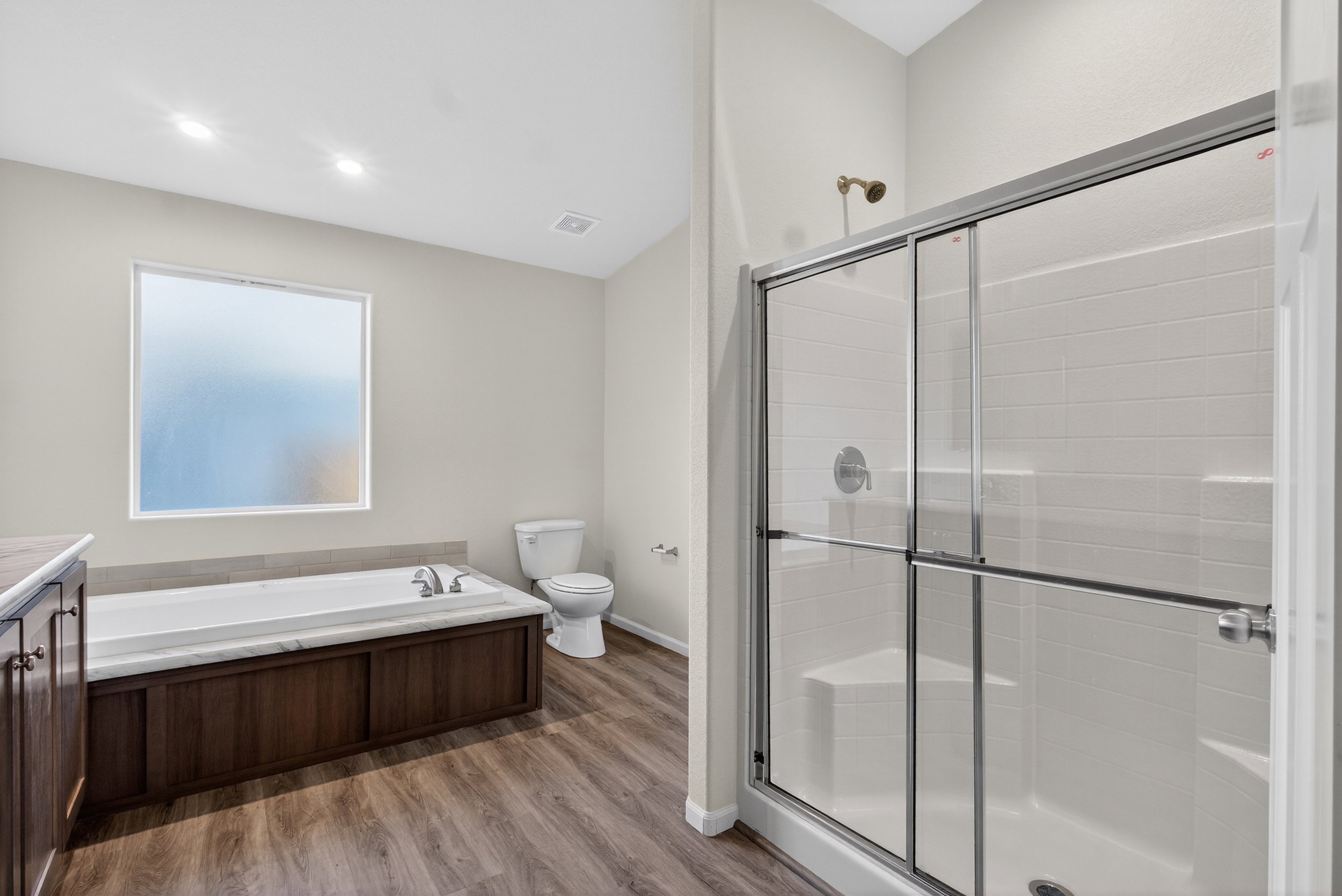 Full bath with vanity, a stall shower, a bath, light wood-style floors, and recessed lighting
