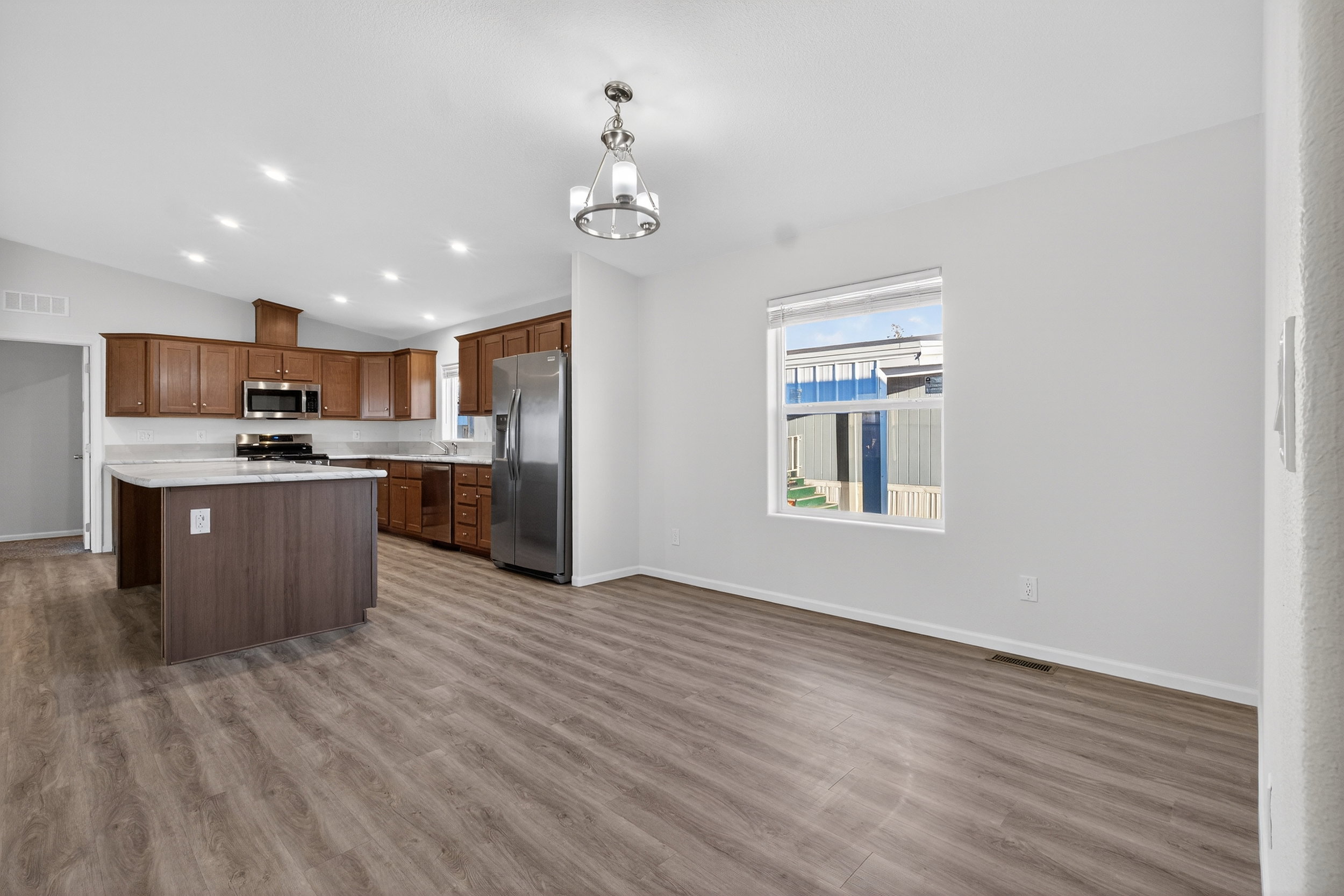 Kitchen with light countertops, vaulted ceiling, stainless steel appliances, recessed lighting, and decorative light fixtures