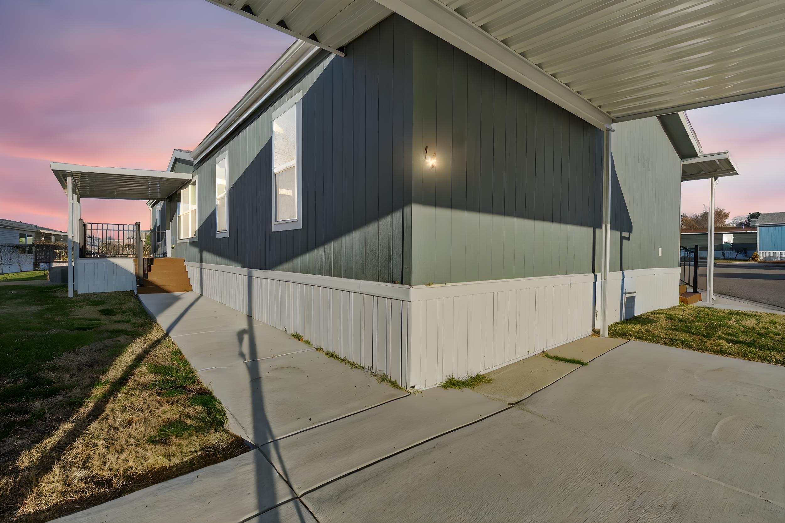 Property exterior at dusk featuring a porch and a yard