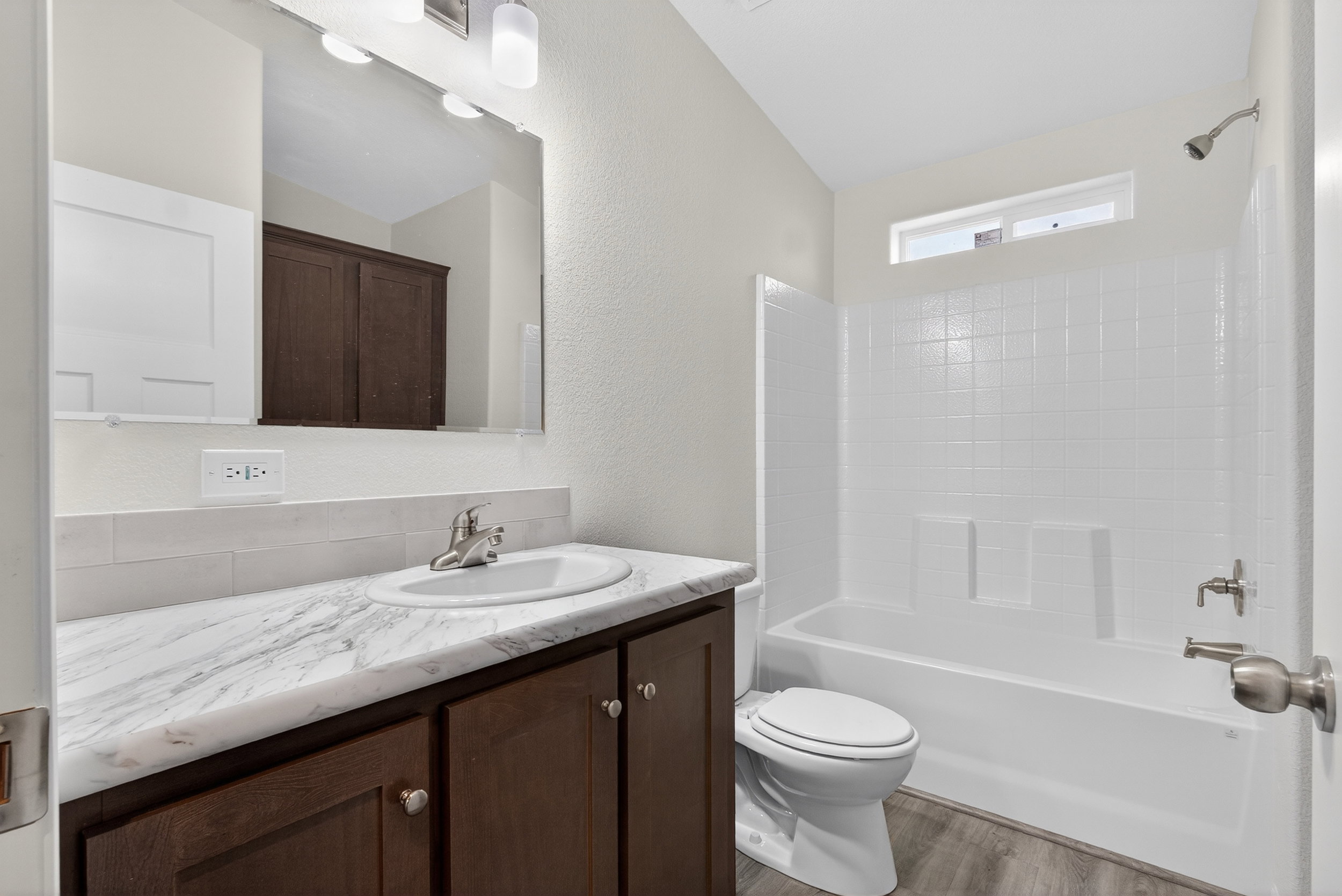 Bathroom with vanity, shower / bath combination, light wood-type flooring, and a textured wall