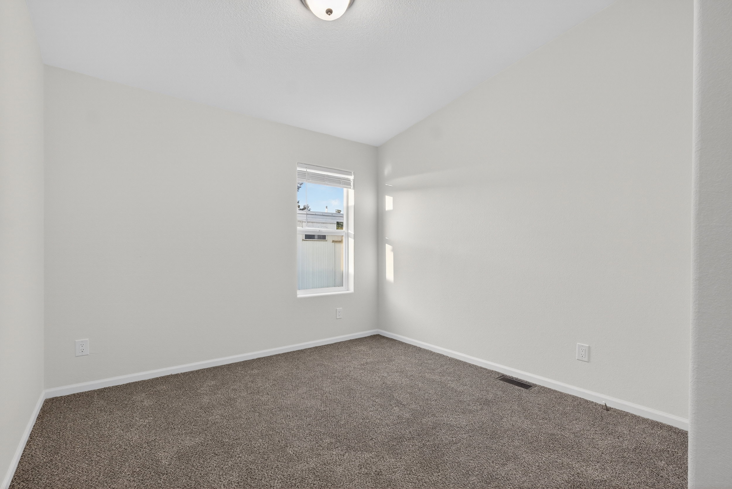 Spare room featuring carpet floors and baseboards