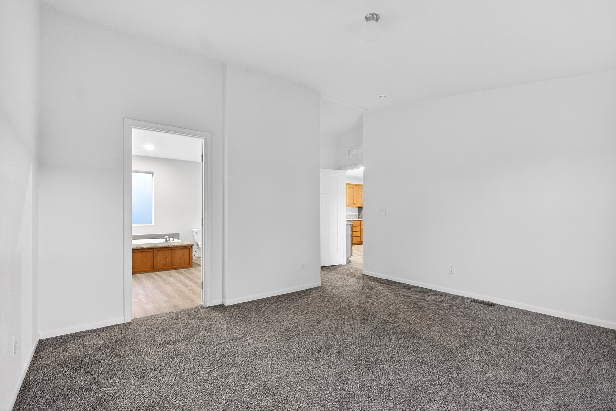 Unfurnished bedroom with carpet floors and ensuite bathroom
