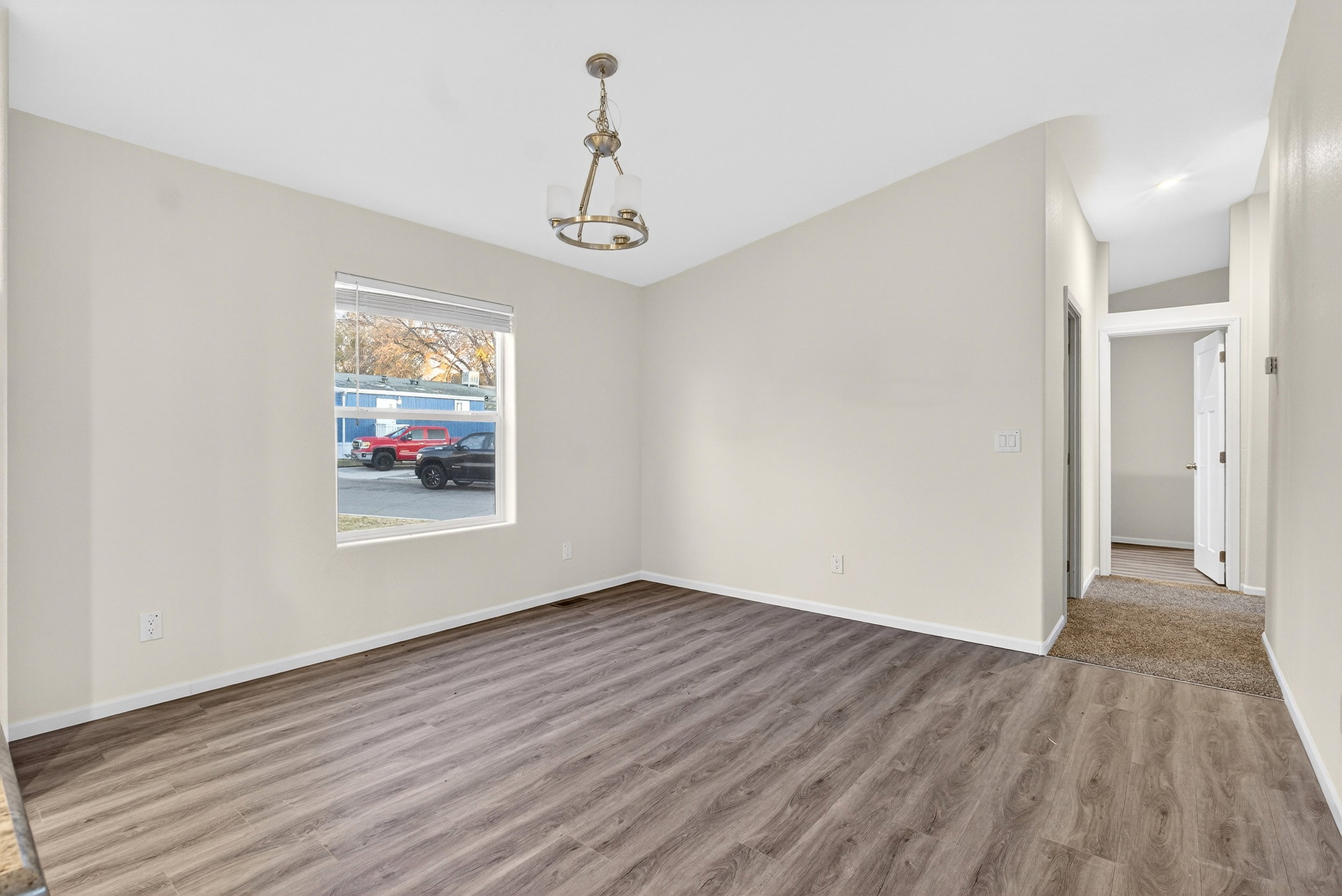 Unfurnished dining area featuring wood finished floors and a chandelier
