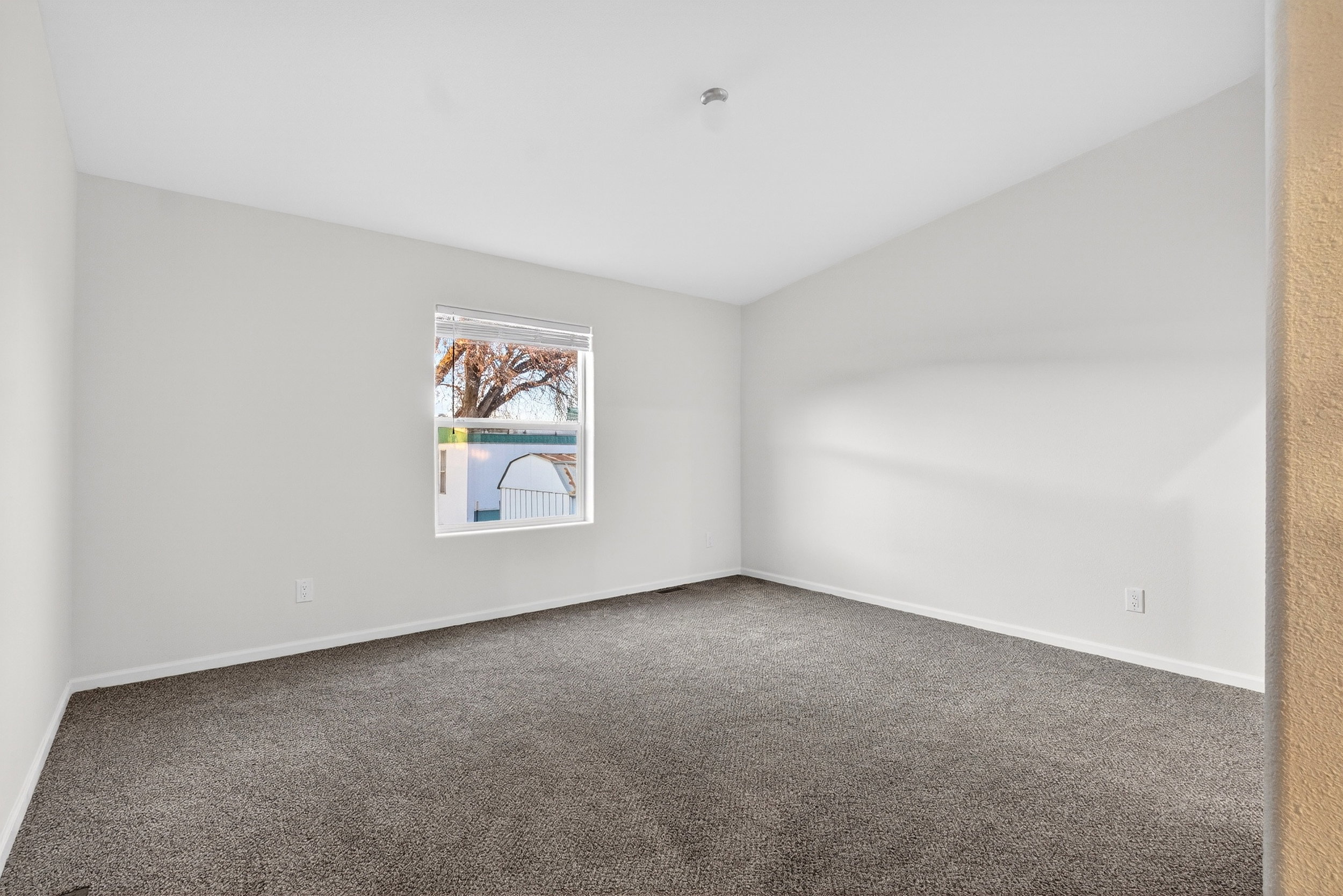 Carpeted spare room featuring baseboards