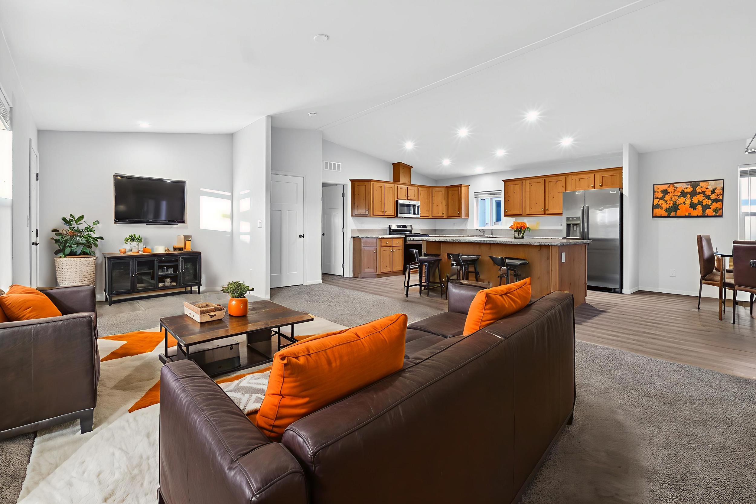 *Virtually staged* Living area with vaulted ceiling, light carpet, healthy amount of natural light, and recessed lighting