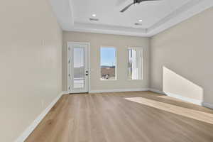 Entrance foyer featuring light wood-type flooring, ceiling fan, a tray ceiling, and recessed lighting