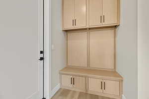 Mudroom with light wood-type flooring and baseboards