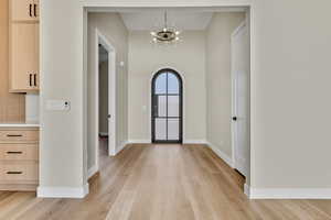 Foyer featuring a chandelier and light wood-type flooring